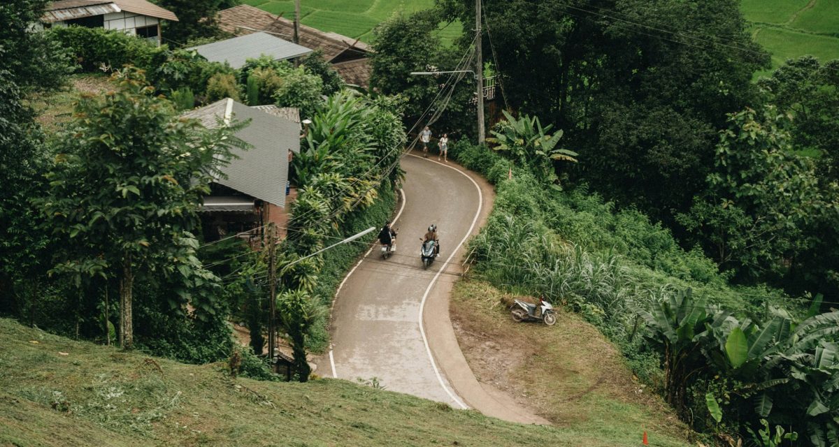 Scooters sur une route verdoyante d’Asie du Sud-Est