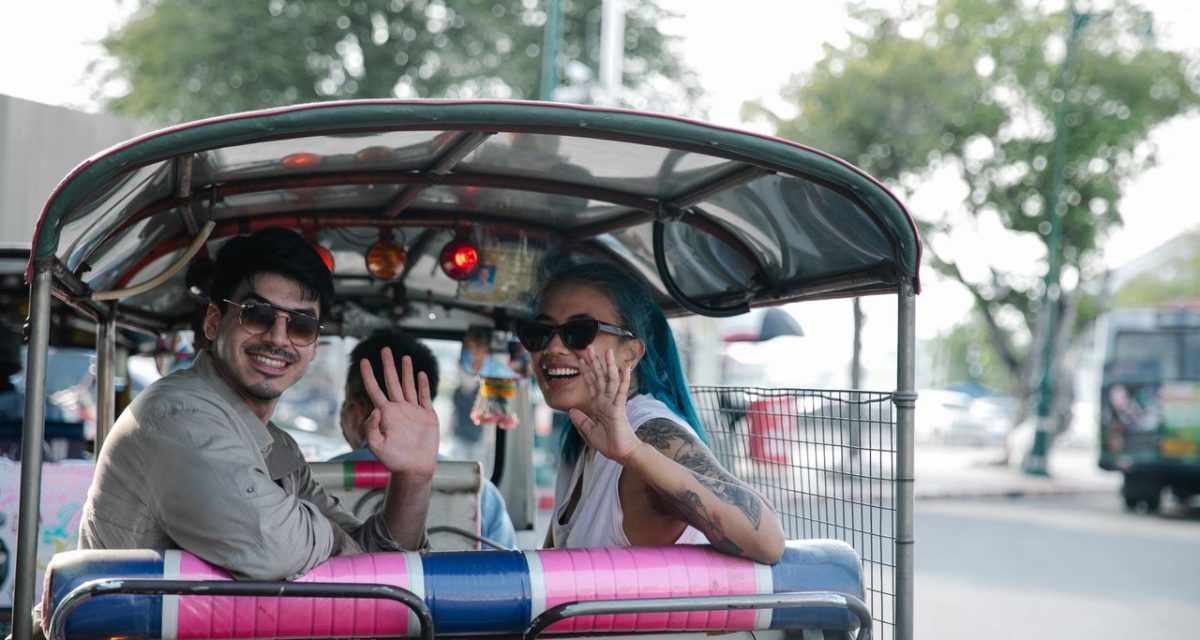 Un couple explore le Laos en tuk-tuk, un moyen de transport emblématique pour les voyageurs